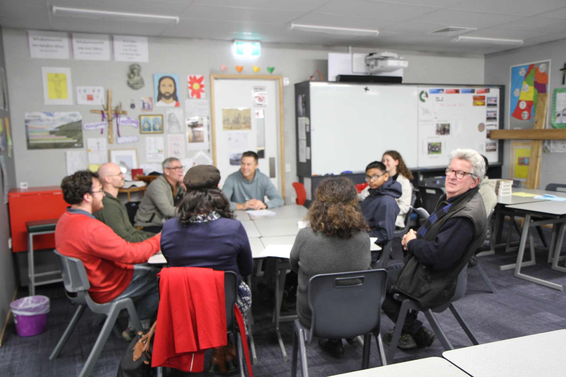 A tutor leading a discussion around the tables during How to Think Like a Westerner