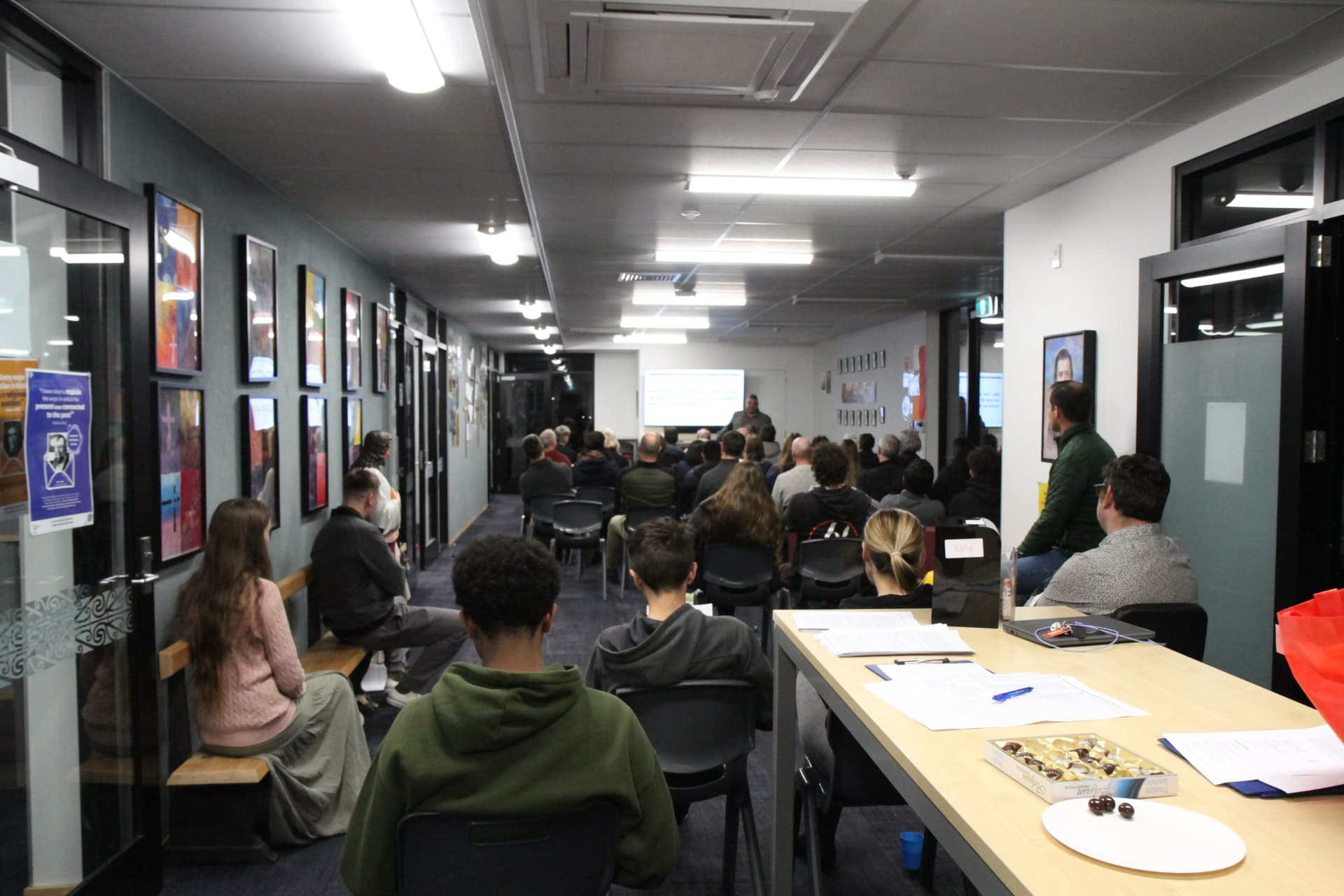The evening audience gathered for a lecture in the hallway room