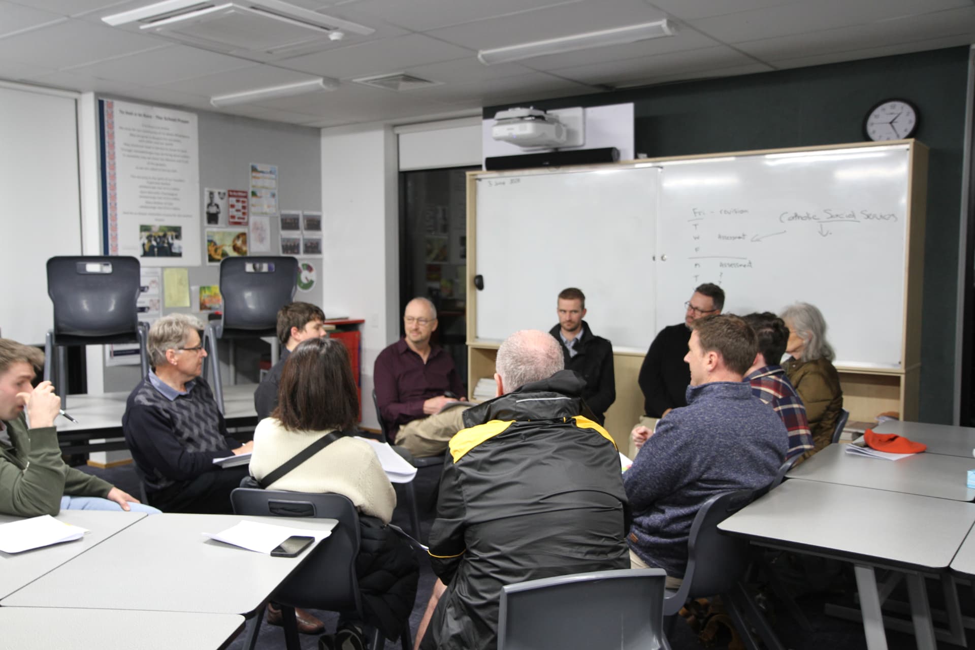 A tutor listening during small group discussion at the course