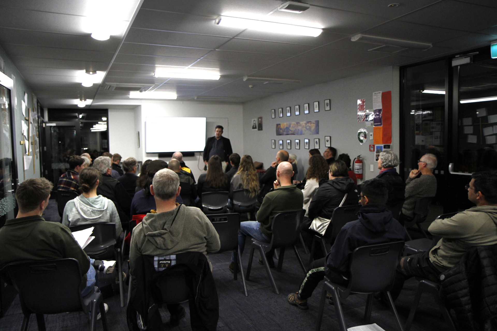 A tutor speaking in front of the screen during a course session