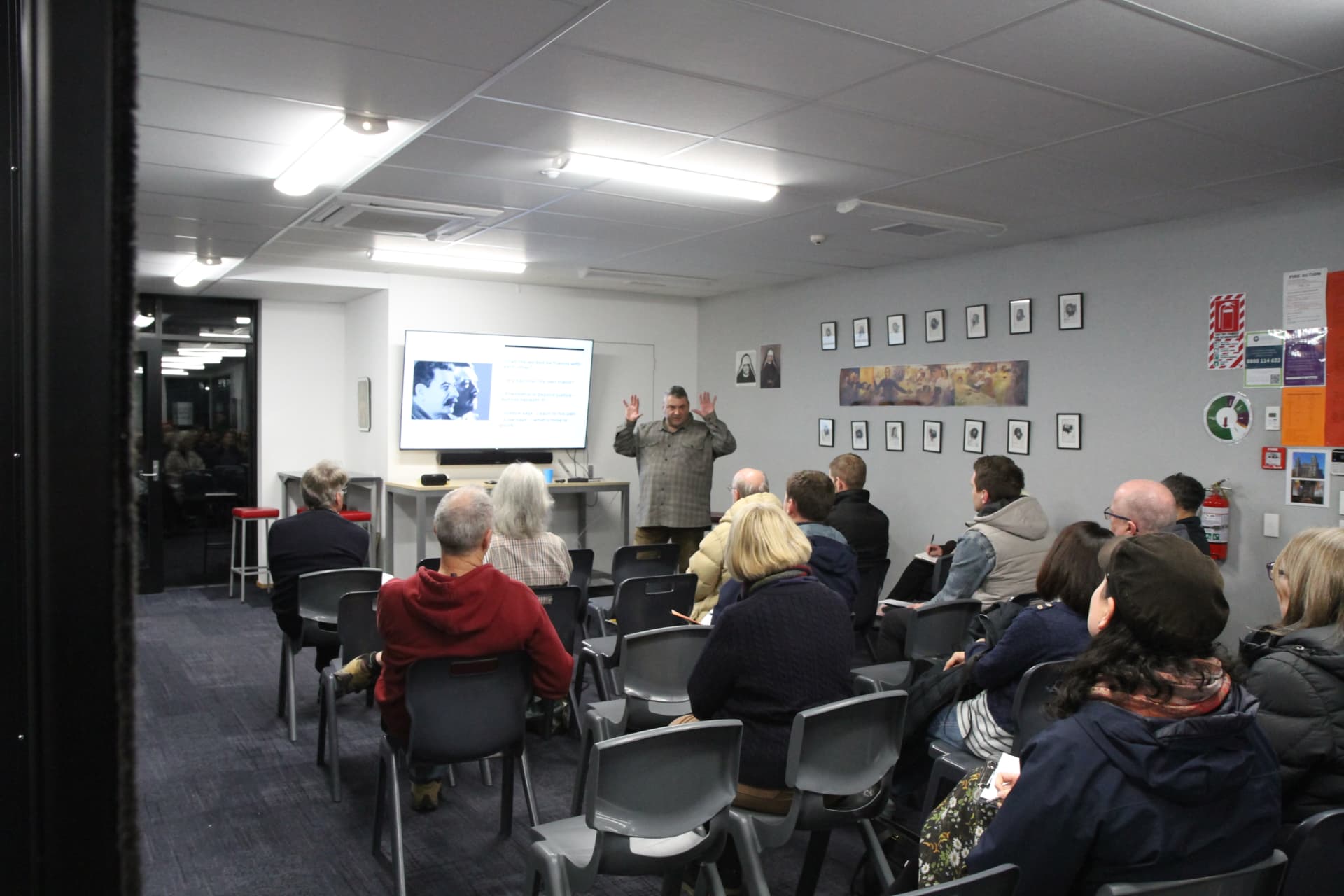 An evening lecture in progress with the full audience seated