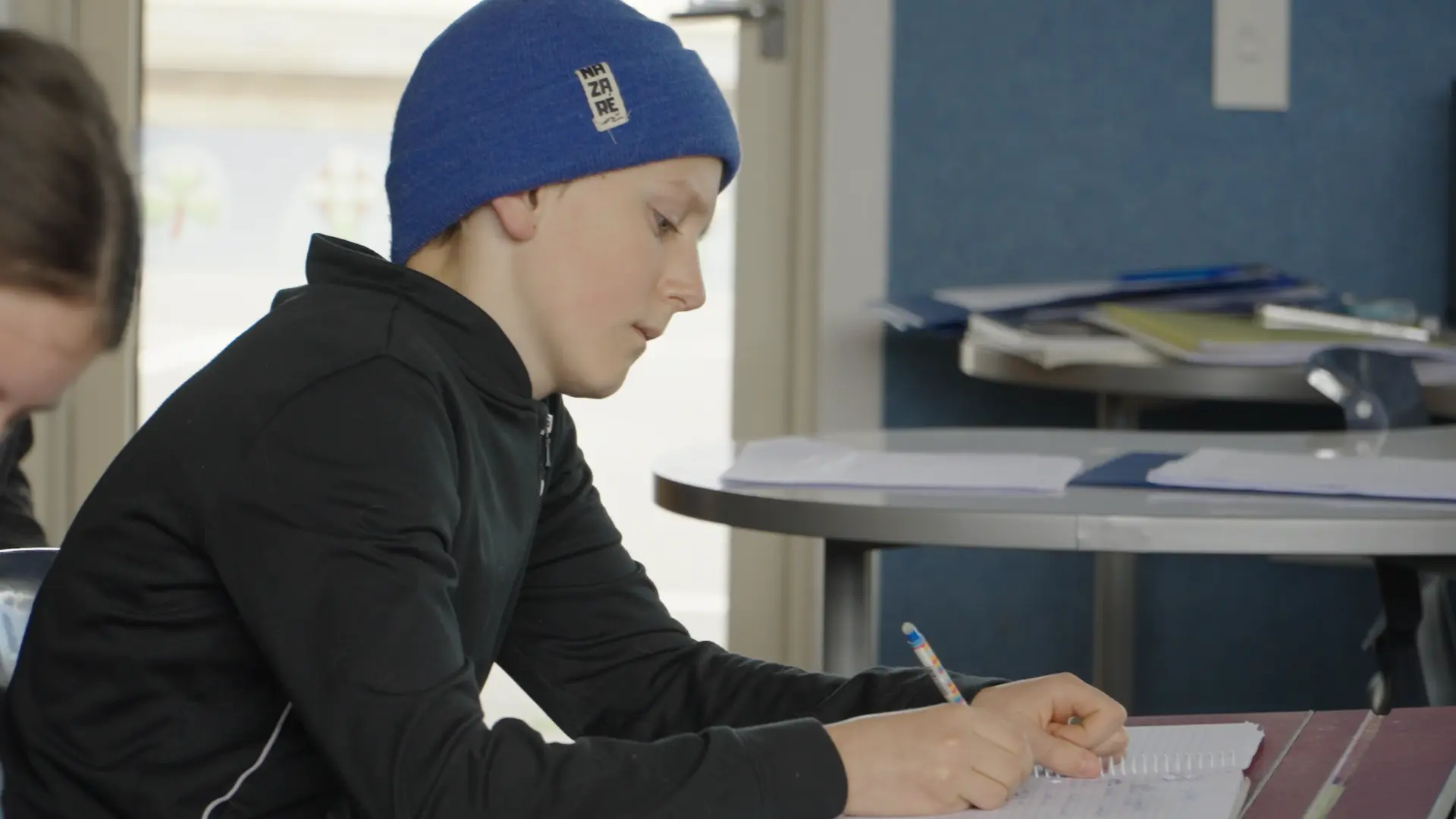 A student writing at his desk at the 2024 Intensive