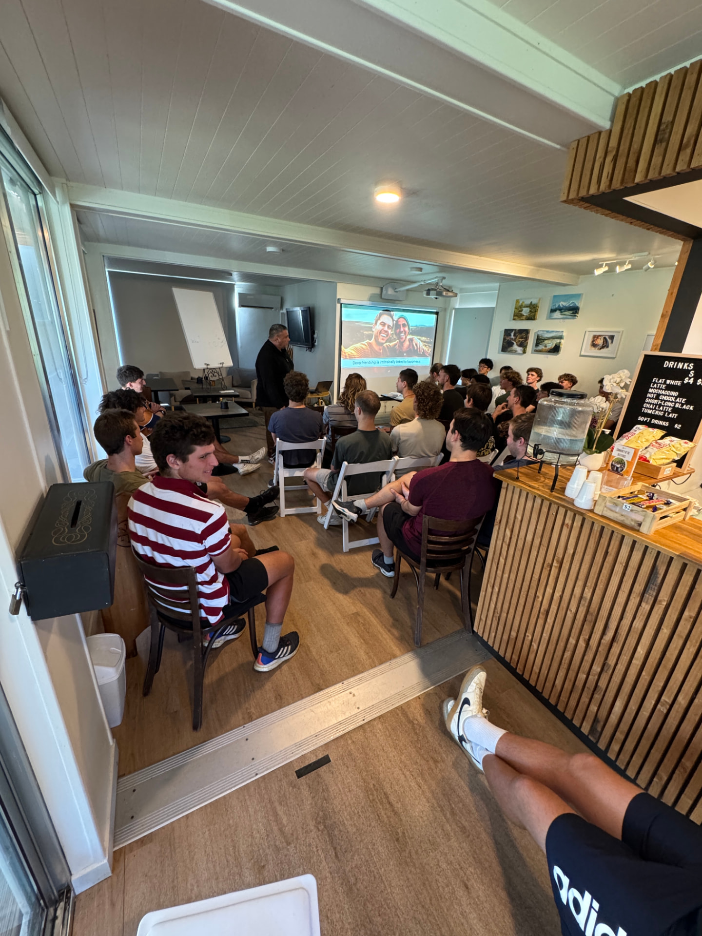 The session in the cafe room with the young men seated and listening
